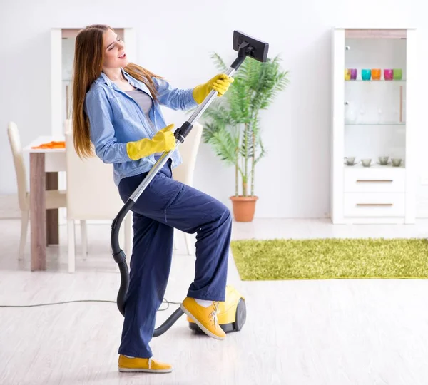 Young woman cleaning floor at home doing chores