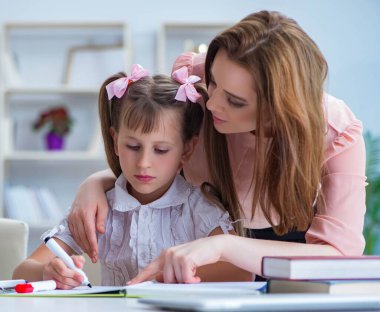 Anne, kızına ödevlerinde yardım ediyor.