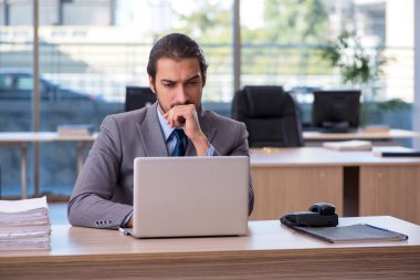 Ofiste çalışan genç bir erkek.