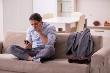 Yorgun genç işadamı işten sonra eve geliyor.