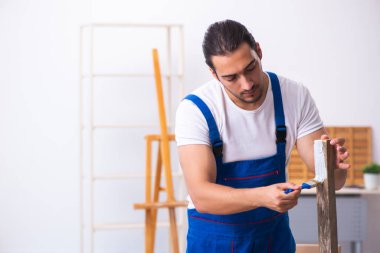 Genç erkek müteahhit atölyede çalışıyor.