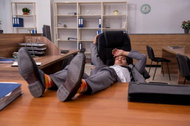 İş yerinde uyuyan genç bir erkek işçi.