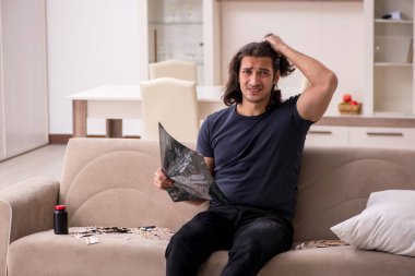 Evde acı çeken genç hasta adam.