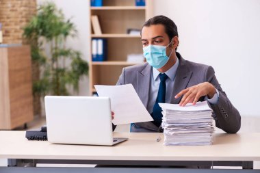 Salgın sırasında maske takan genç bir erkek.