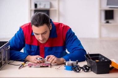 Bilgisayar tamir eden genç bir erkek tamirci.