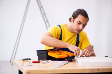 Genç erkek marangoz içeride çalışıyor.