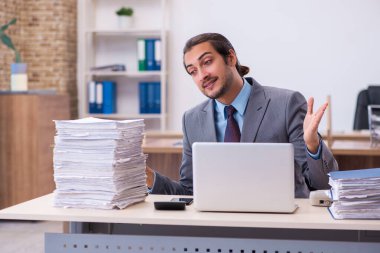 Ofisteki aşırı işten memnun olmayan genç bir erkek işçi.