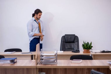 Ofiste beysbol sopası tutan öfkeli genç bir çalışan var.