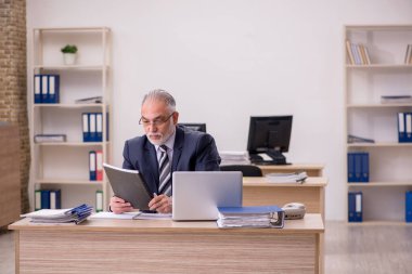 Ofiste oturan yaşlı işadamı