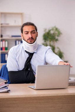 Ofiste çalışırken kaza geçirmiş genç bir adam.