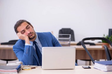 Genç erkek çalışan işyerinde yeni doğan çocuğa bakıyor.