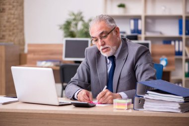 Ofiste çalışan yaşlı bir erkek.