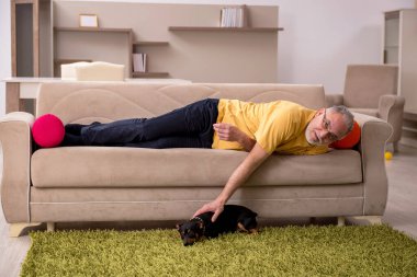 Evde köpeği olan yaşlı bir adam.