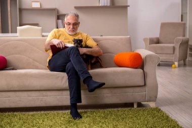 Evde köpeği olan yaşlı bir adam.