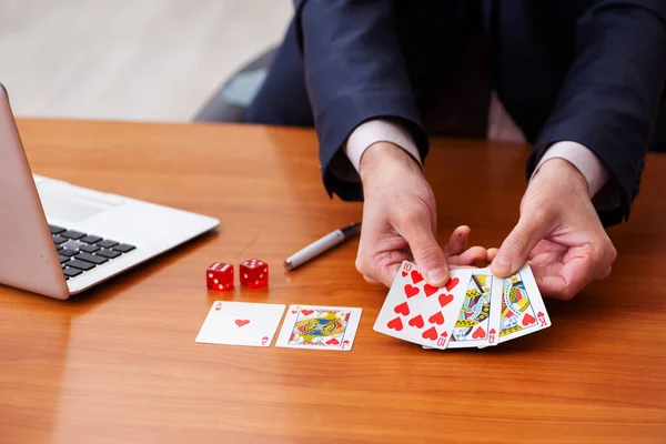 Old male employee playing cards at workplace