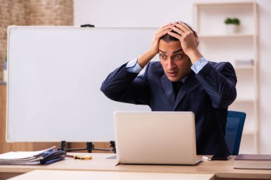 Beyaz yönetim kurulunun önünde genç bir erkek işveren.