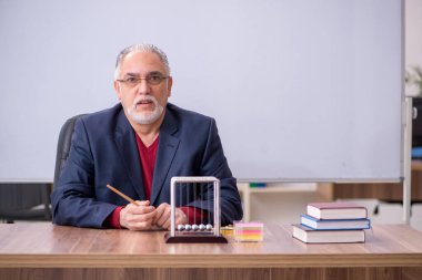 Sınıfta oturan eski bir fizikçi öğretmen.