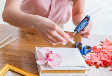 Hatıra defteri konseptinde resim çerçevesi dekore eden kadın