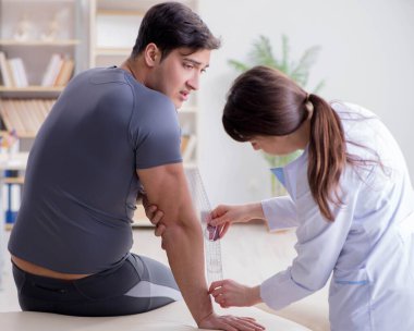 Doktor hastaların eklem esnekliğini gonimetreyle kontrol ediyor.