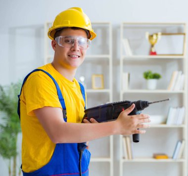 Elektrikli matkapla genç bir tamirci.