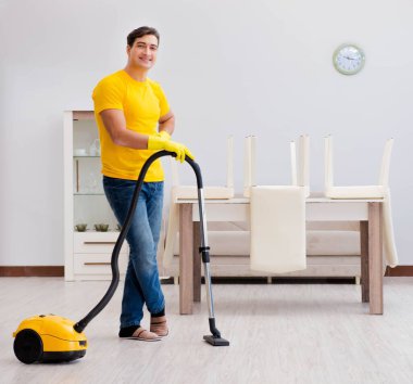 Koca adam evi temizliyor, karısına yardım ediyor.