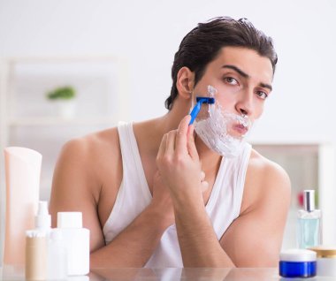 Genç yakışıklı adam sabah erkenden tıraş oluyor.