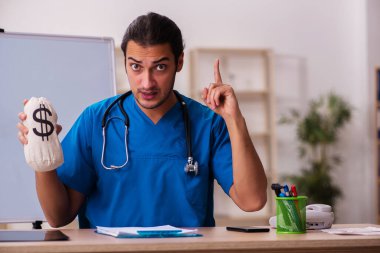 Klinikte çalışan genç erkek doktor.