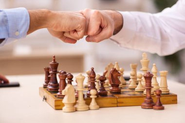 Ofiste satranç oynayan iki işadamı.