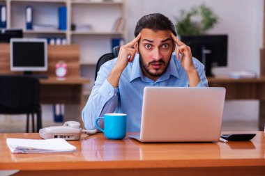 Ofiste çalışan genç bir erkek.