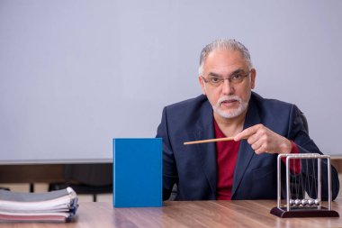 Sınıfta oturan eski bir fizikçi öğretmen.