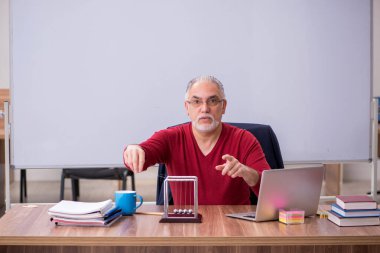 Sınıfta oturan eski bir fizikçi öğretmen.