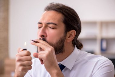 Genç erkek çalışan ve ofiste çok fazla hamamböceği var.