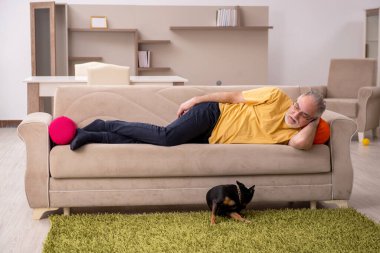 Evde köpeği olan yaşlı bir adam.