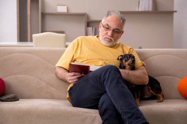 Evde köpeği olan yaşlı bir adam.