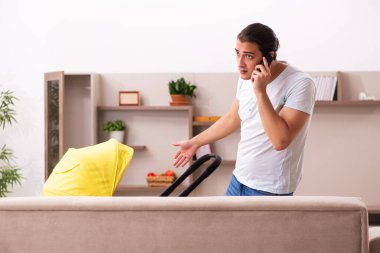 Genç erkek müteahhit evde yeni doğan çocuğa bakıyor.