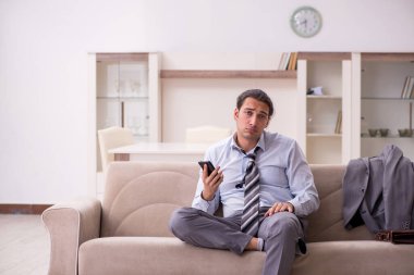 Yorgun genç işadamı işten sonra eve geliyor.