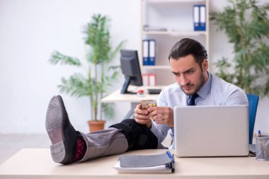 Ofiste çalışan genç bacağı yaralı bir çalışan.