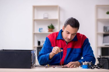 Bilgisayar tamir eden genç bir erkek tamirci.