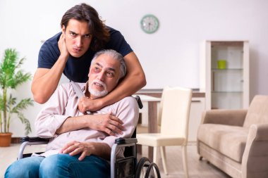 Tekerlekli sandalyedeki yaşlı adam ve genç kötü bakıcı.