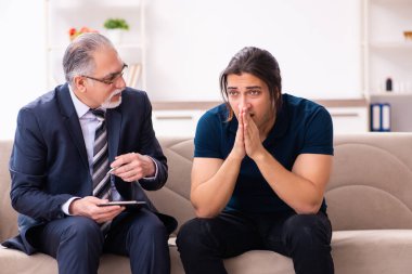 Genç adam yaşlı erkek psikoloğu ziyaret ediyor.