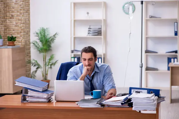 Giovane dipendente maschile che soffre sul posto di lavoro — Foto Stock