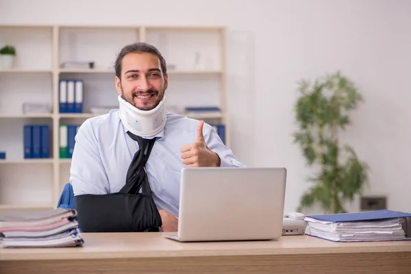 Young man after accident working in the office