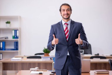 Genç işadamı ofiste oturuyor.