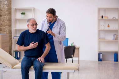 Yaşlı erkek hasta genç erkek doktoru ziyaret ediyor.