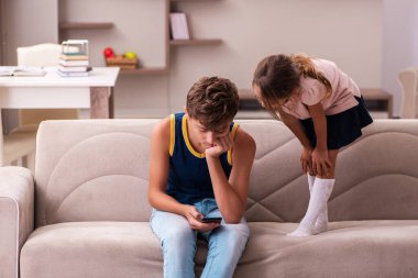 Oğlan ve küçük kız kardeşi salgın sırasında evde kalıyorlar.