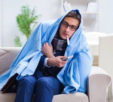 Çalışan işadamı grip olmuşken televizyon izliyor.