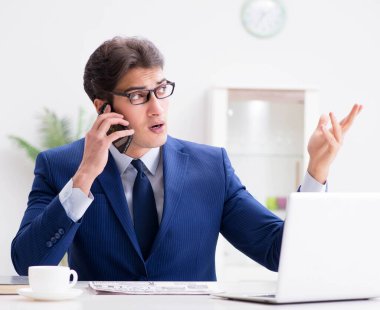 İşadamı ofis telefonundan konuşuyor.