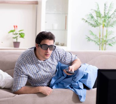 Evde 3D televizyon izleyen bir adam.