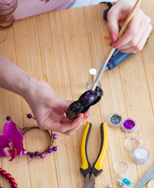 Kadın evde mücevher yapıyor.