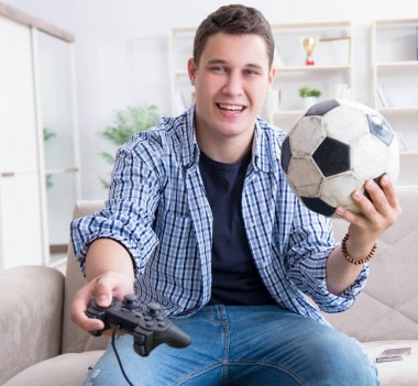 Genç adam evde bilgisayar oyunu oynuyor.